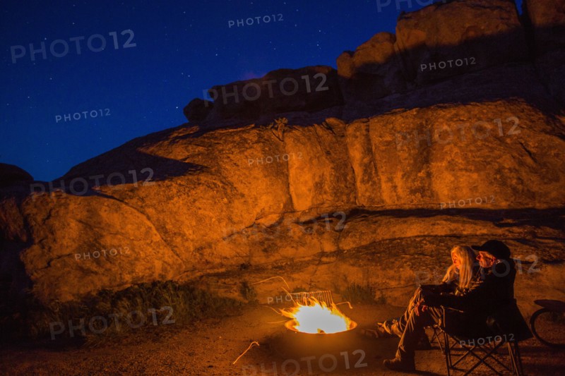 Caucasian couple near campfire at night