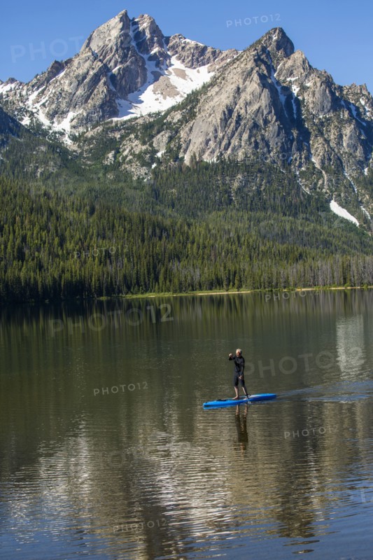 Caucasian man on paddleboard on mountain lake