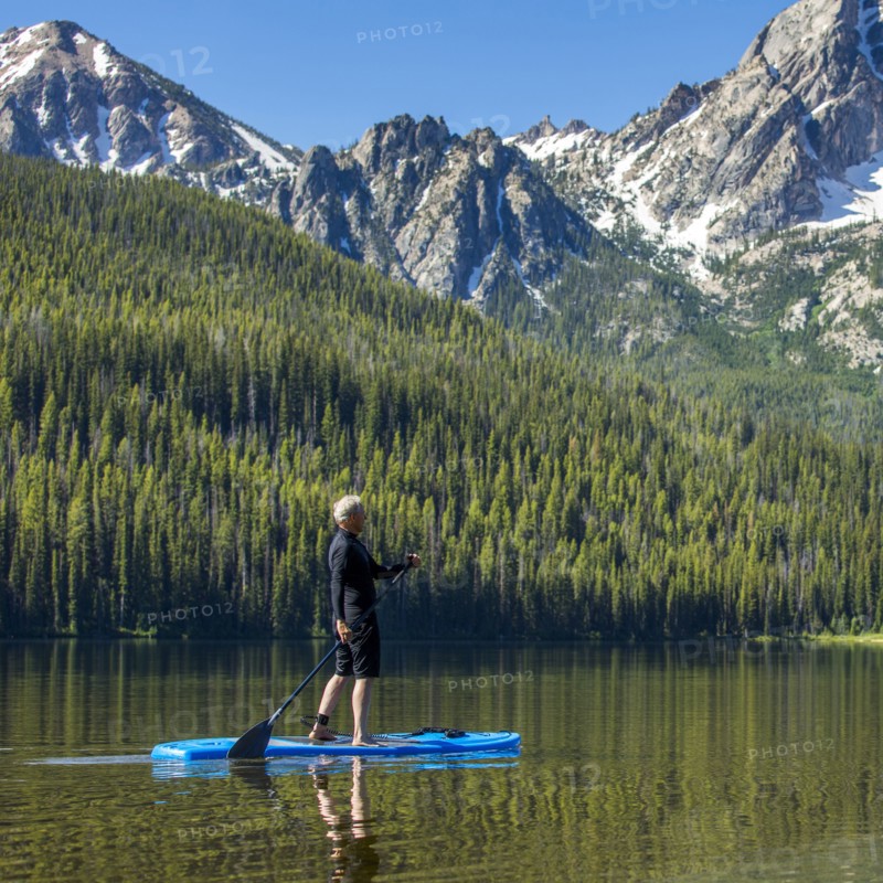 Caucasian man on paddleboard on mountain lake