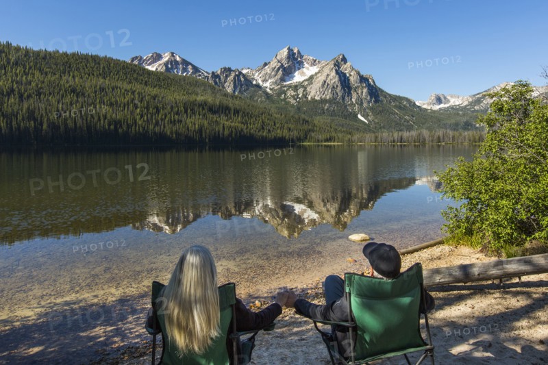 Caucasian couple holding hands at mountain lake