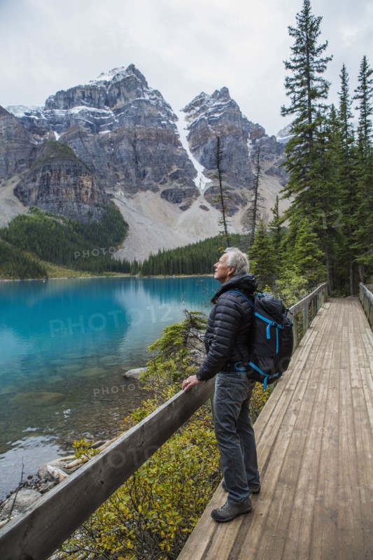 Caucasian man standing on boardwalk admiring mountain
