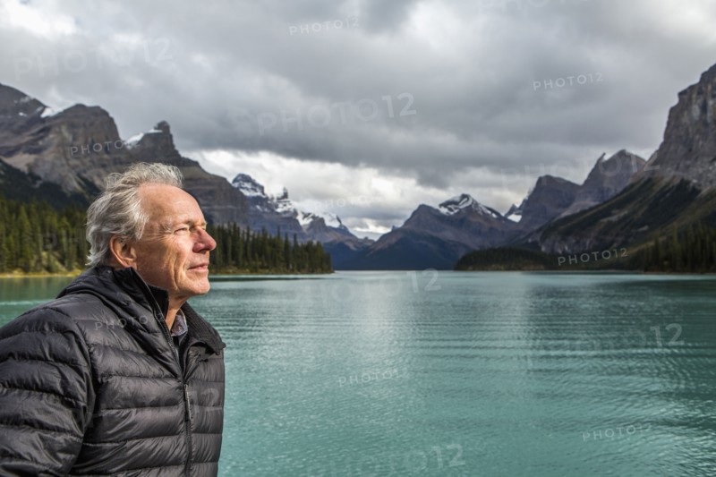 Caucasian man standing near mountain lake