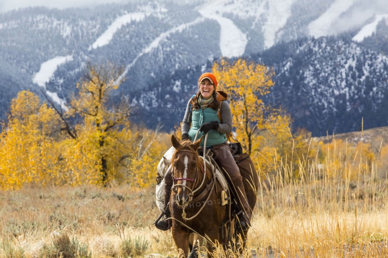 Laughing Caucasian woman riding horse in winter