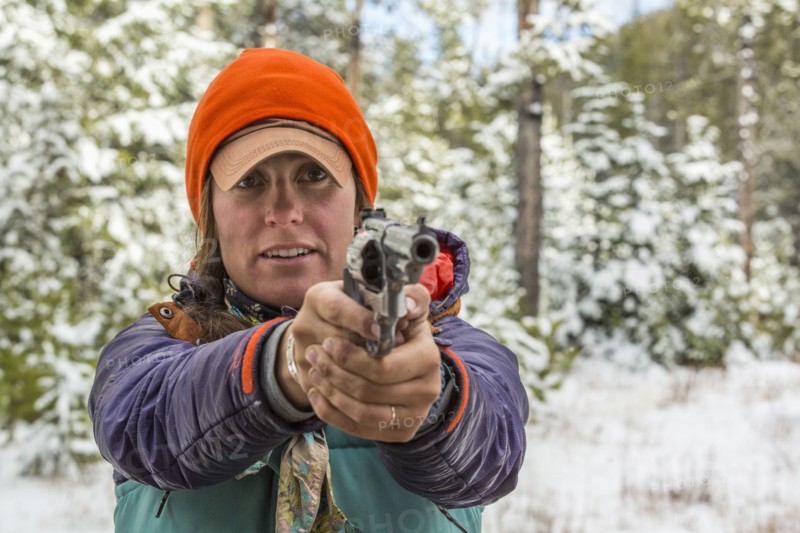 Caucasian woman aiming handgun in winter