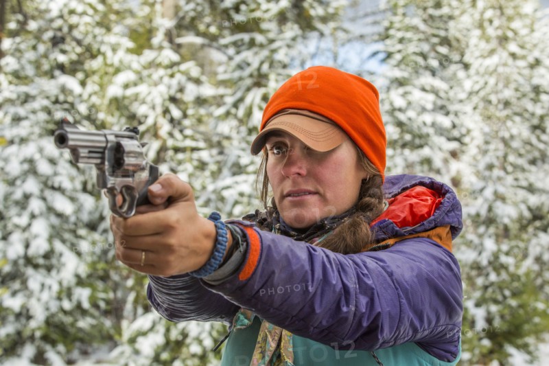Caucasian woman aiming handgun in winter