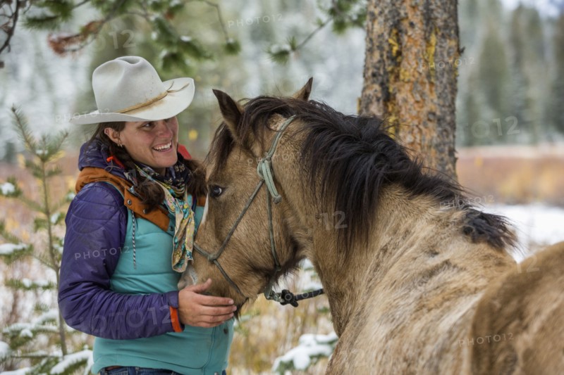 Caucasian woman petting horse in winter