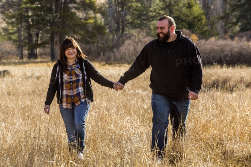 Caucasian couple holding hands in field