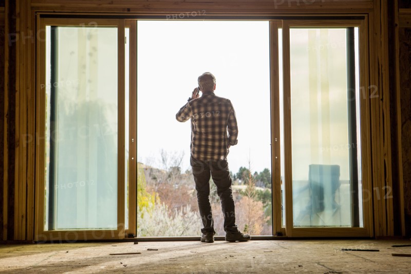 Caucasian man talking on cell phone in doorway