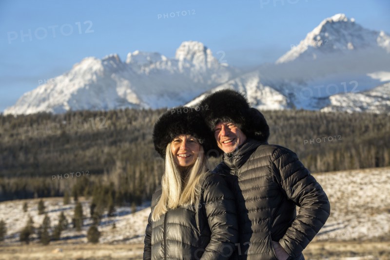 Caucasian couple smiling near mountains in winter