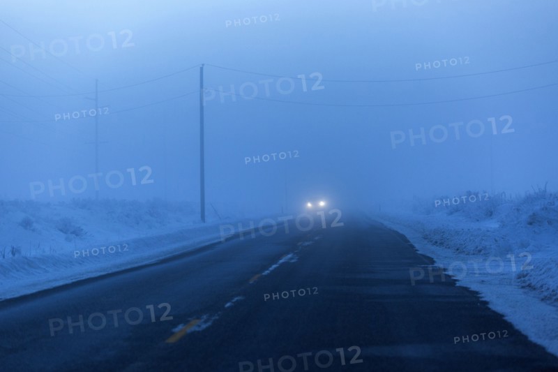Approaching headlights from car driving in winter