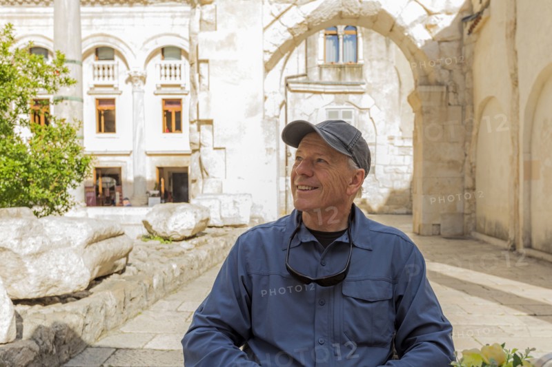 Smiling older Caucasian man sitting in garden