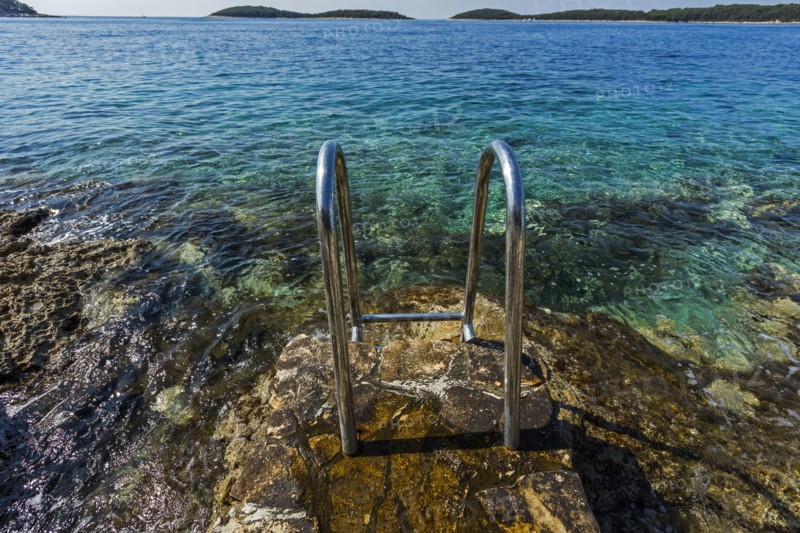 Metal railing on rocks at ocean