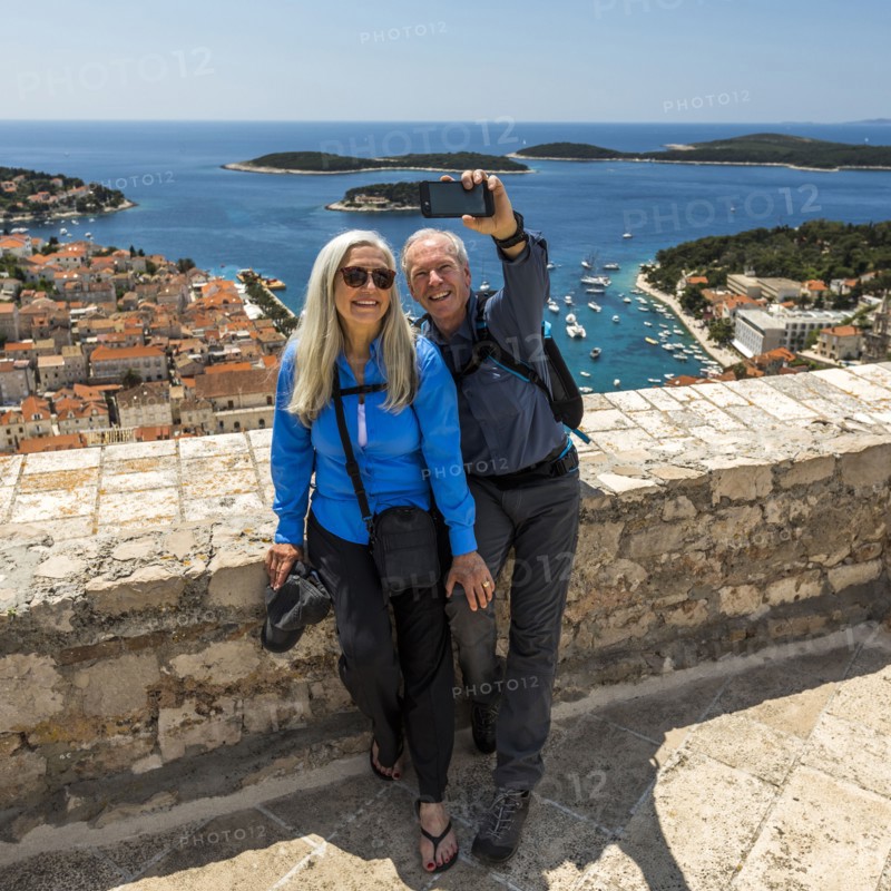Caucasian couple posing for cell phone selfie with scenic view of ocean