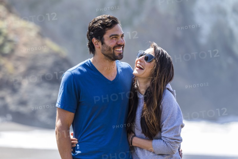 Couple laughing and hugging on beach