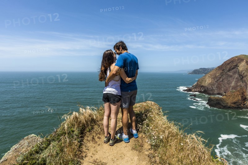 Couple hugging near scenic view of ocean