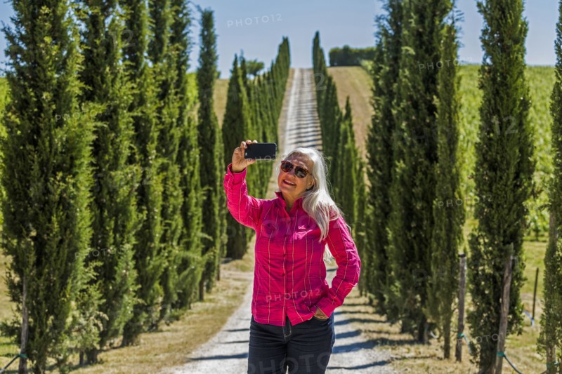 Caucasian woman posing for cell phone selfie on dirt road