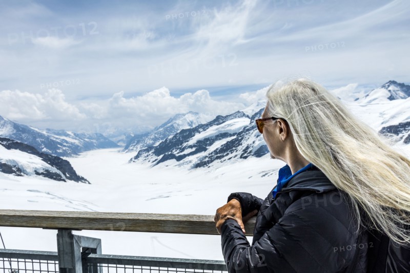 Caucasian woman leaning on railing admiring scenic view of mountains