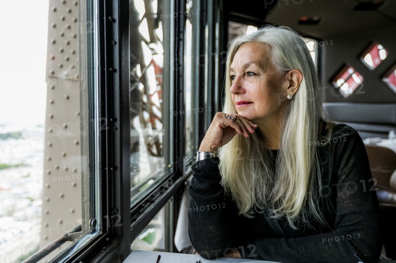 Caucasian woman admiring scenic view from restaurant window