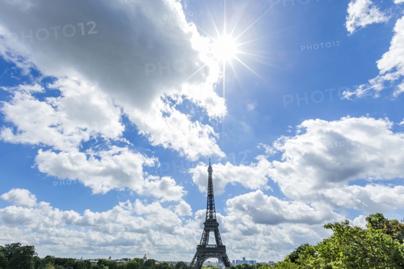 Sunbeams over distant Eiffel Tower