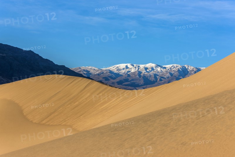 Sand dunes near snowy mountain range
