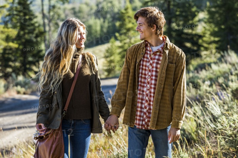 Smiling Caucasian couple holding hands outdoors