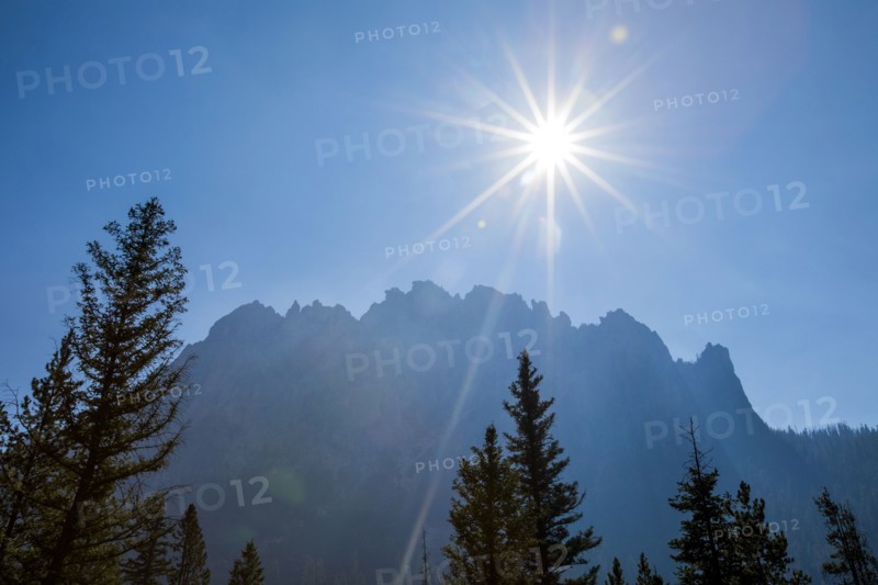 Sunbeams over trees near mountain