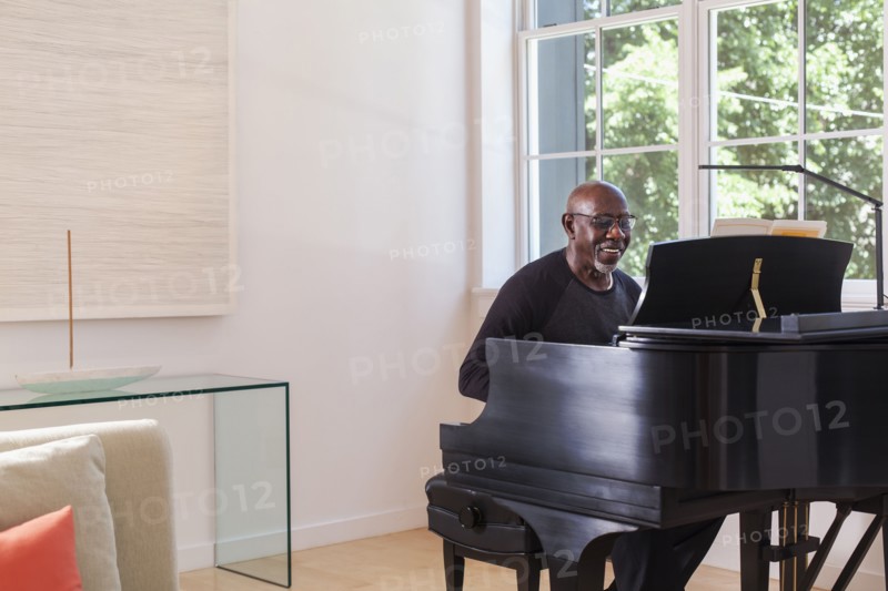 Man playing piano near window