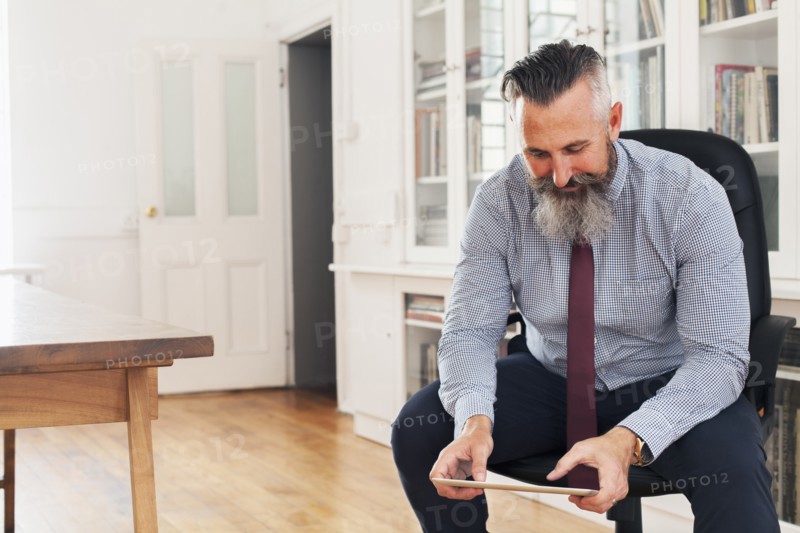 Caucasian businessman sitting on chair using digital tablet