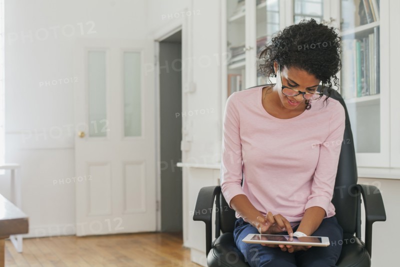 Mixed Race woman using digital tablet