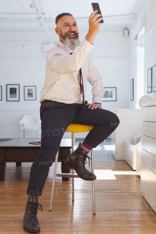 Smiling Caucasian businessman posing for cell phone selfie