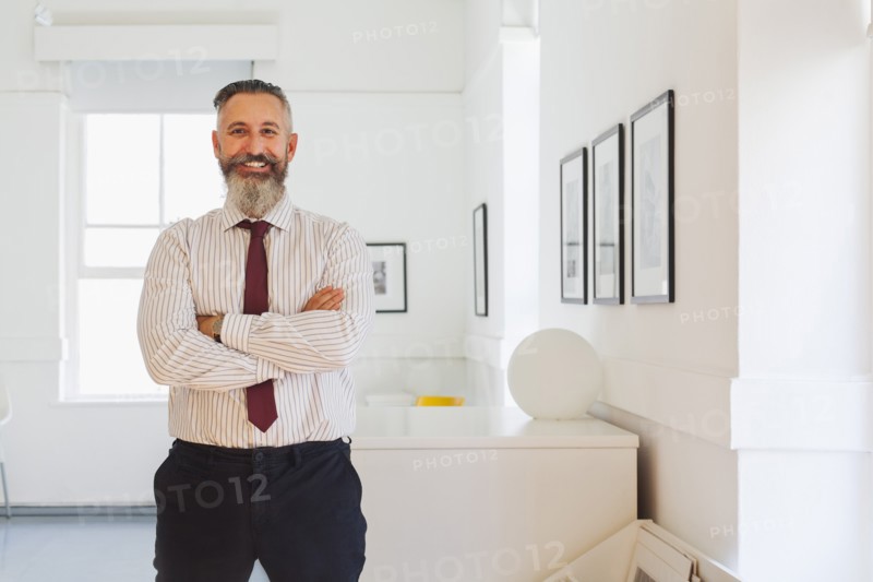 Portrait of smiling Caucasian businessman with arms crossed
