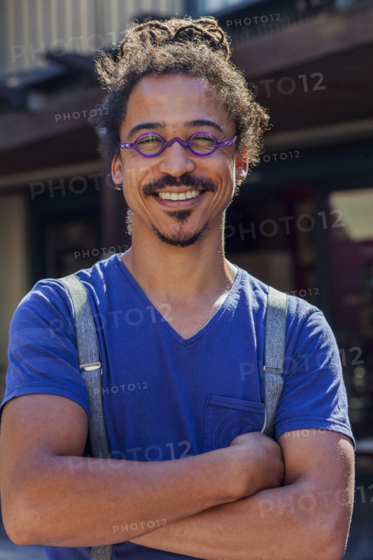 Smiling mixed race man wearing suspenders