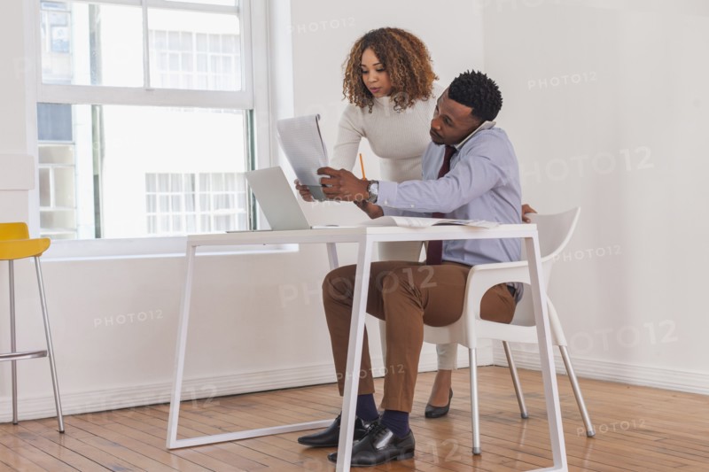 Business people talking on cell phone and reading notepad