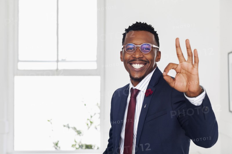 Black man gesturing okay in gallery