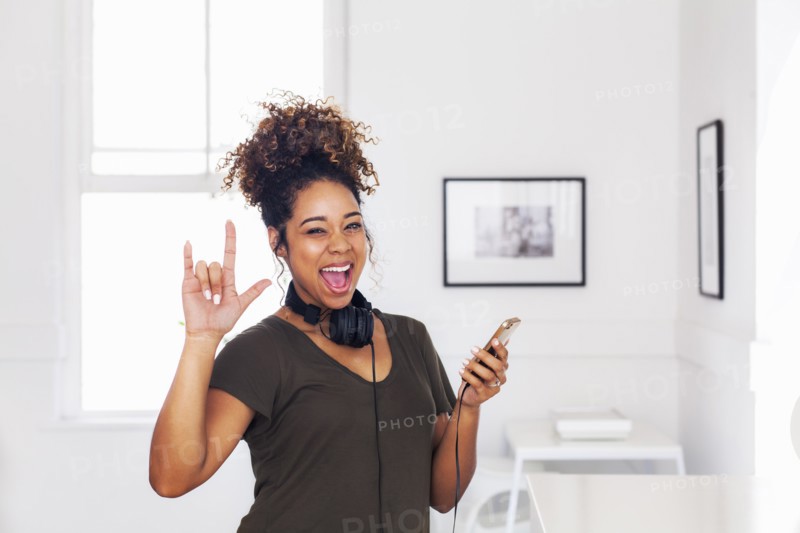 Mixed race woman gesturing and holding cell phone
