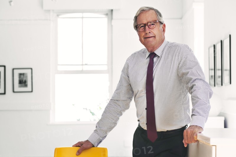 Smiling Caucasian businessman leaning on chair