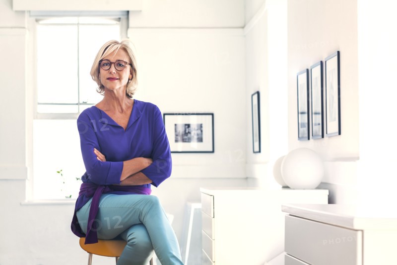 Confident Caucasian woman sitting on stool