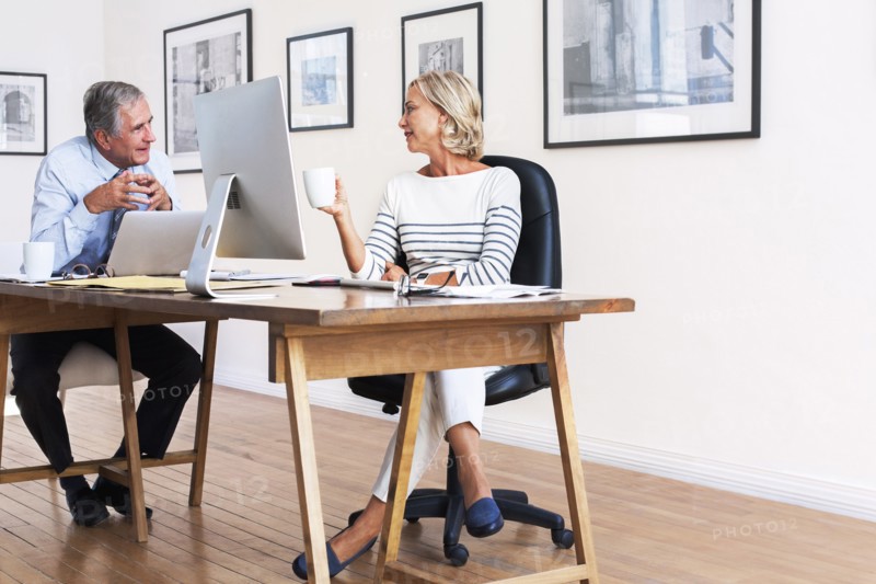 Caucasian businessman and businesswoman talking at table