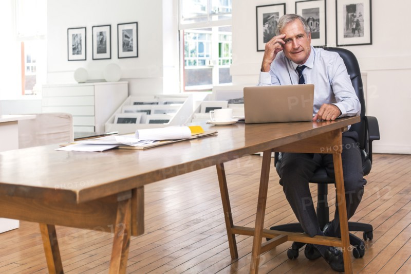 Portrait of frustrated Caucasian businessman using laptop