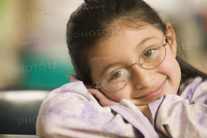 Hispanic girl laying her head on arms