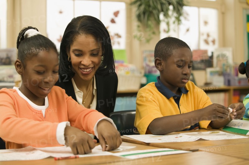 African school teacher helping students
