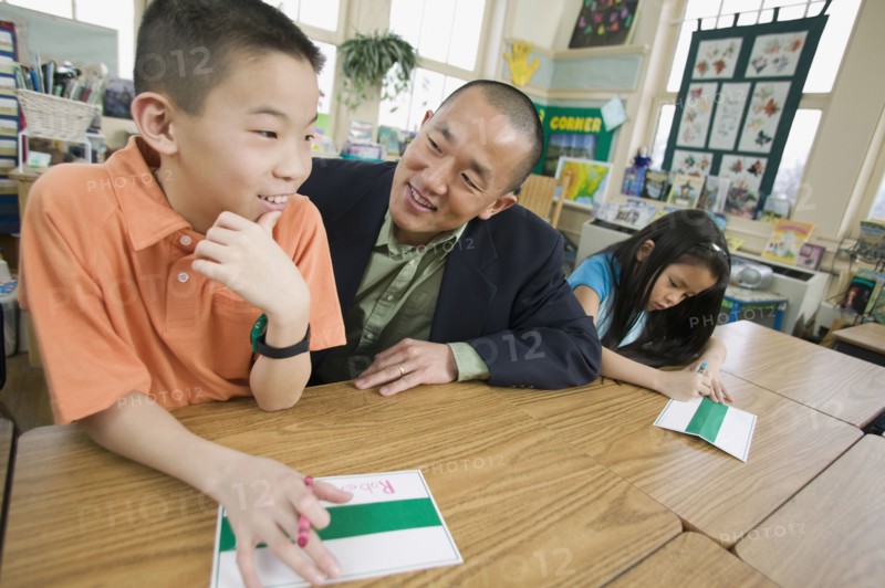 Asian school teacher helping students