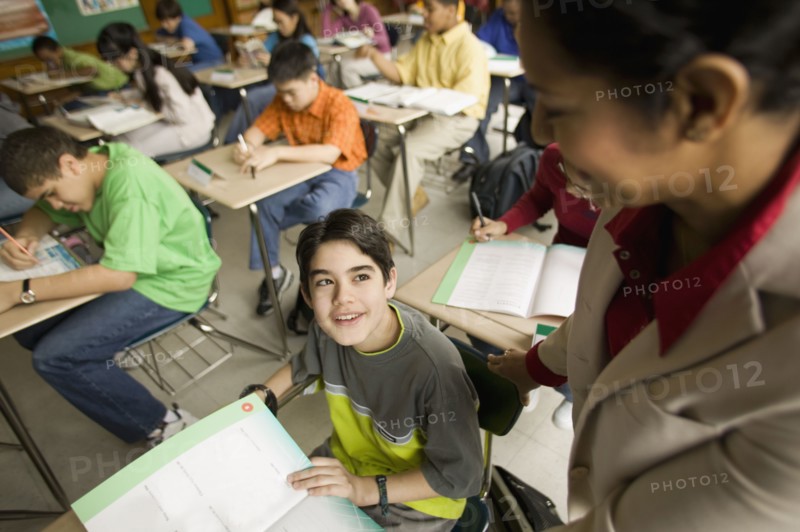 Hispanic school teacher helping student