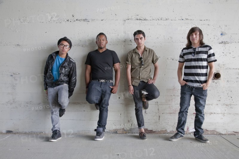 Serious teenage boys leaning against wall