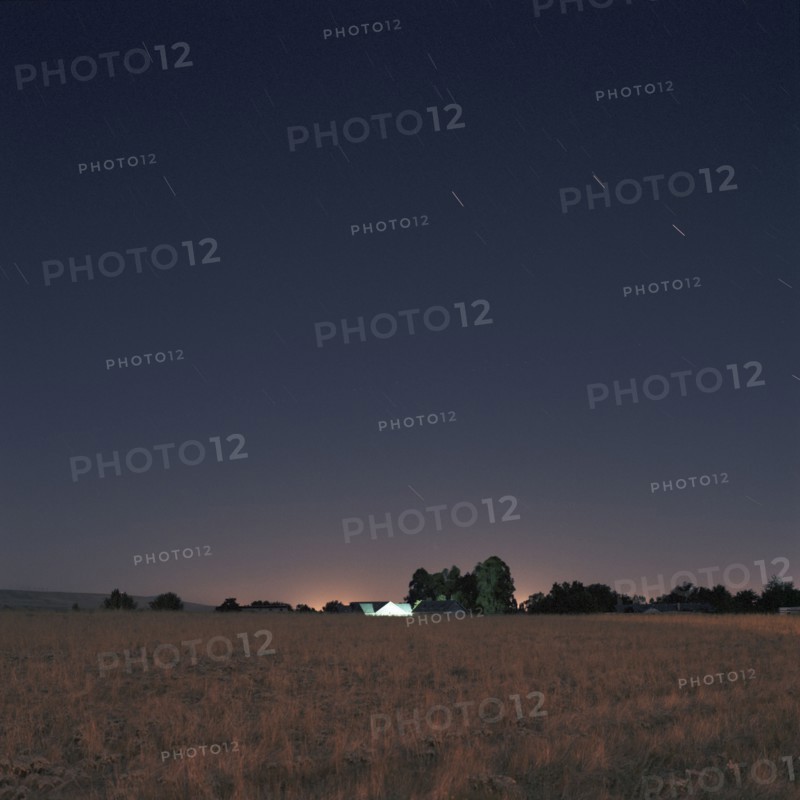 Stars and sunset over field