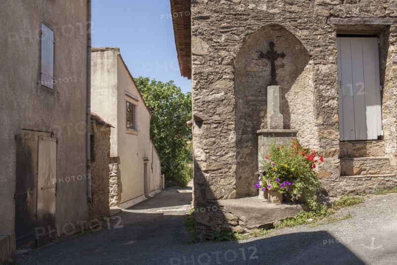 Crucifix shrine in wall alcove on village sidewalk