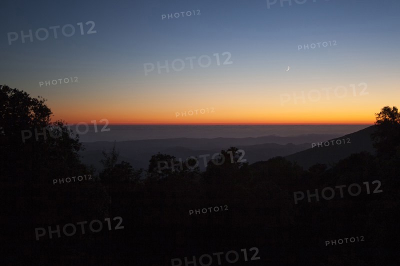Sunset sky over silhouette of remote mountains
