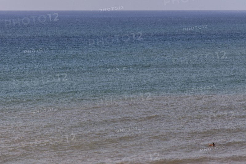 Aerial view of surfer floating on ocean waves