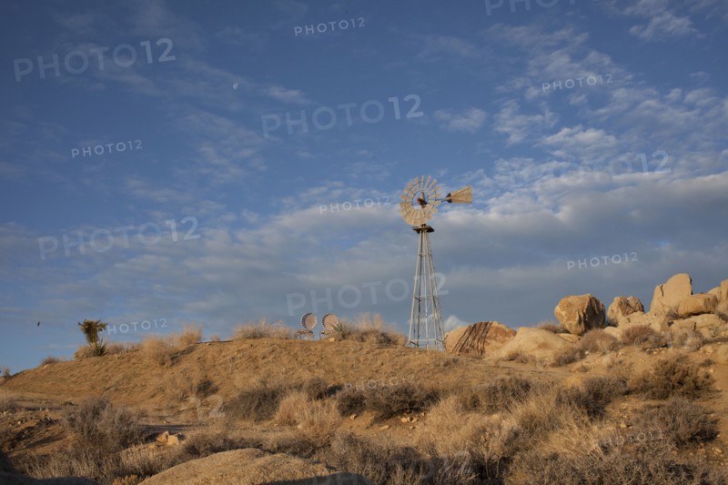 Windmill over rock formations in desert field