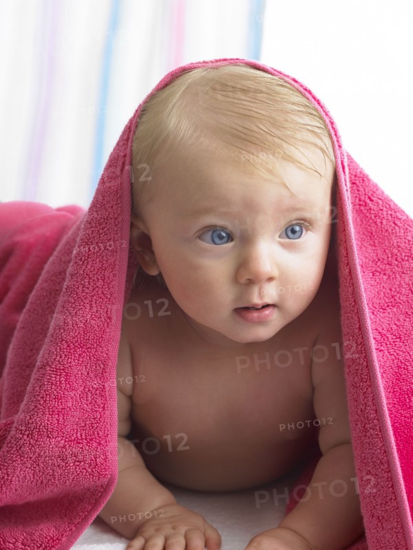 Mixed race baby girl laying under towel